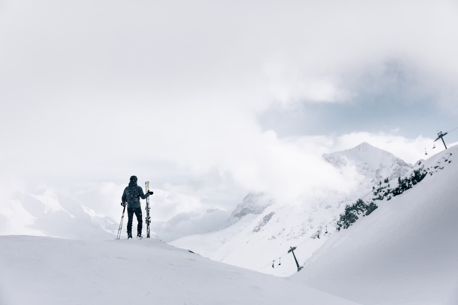 Skiier overlooking snowy mountain ski slopes